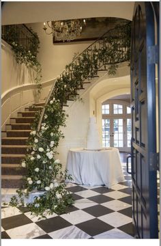 the stairs are decorated with flowers and greenery for an elegant wedding reception at this mansion