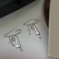 three pairs of silver earrings with dangling stars