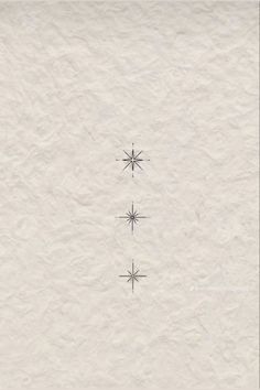 three snowflakes are shown in the middle of a white paper background with black ink