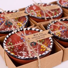 several red bowls with designs on them are wrapped in twine