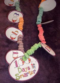 a group of ten days smartie bracelets on top of a purple tablecloth