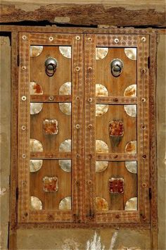 an old wooden door with glass panels and knobs