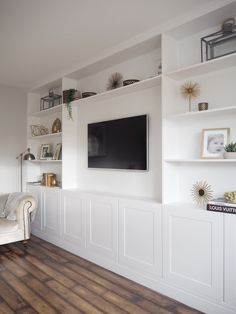 a living room filled with furniture and a flat screen tv mounted on the wall above it