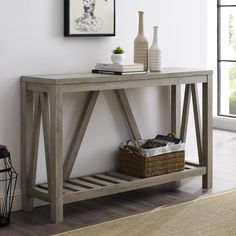 a wooden table sitting on top of a hard wood floor next to a white wall