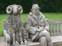 two statues of men sitting on a bench