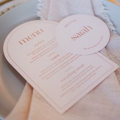 a table setting with two heart shaped menus on top of each other and napkins in the shape of hearts