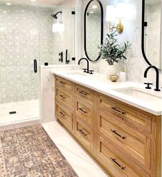 a bathroom with two sinks, mirrors and a rug on the floor in front of it