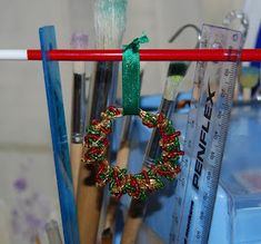 a close up of some paint brushes and christmas wreaths hanging on a clothes line