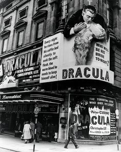 an old black and white photo of people walking in front of a building with dracula on it