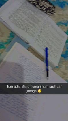 an open book sitting on top of a table next to a pen