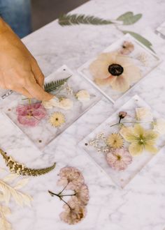 a person placing pressed flowers on some cards