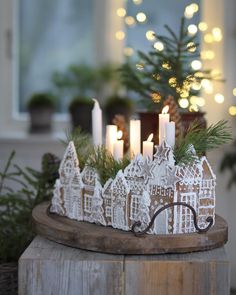 a small christmas village with lit candles in it