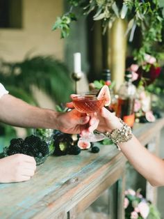 two people toasting each other with drinks