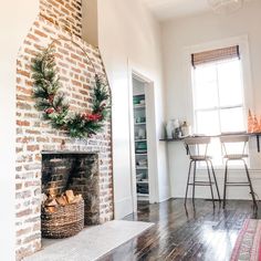 a living room with a brick fireplace and christmas decorations