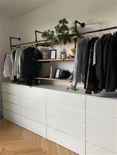 an organized closet with clothes hanging on rails