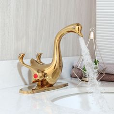 a golden duck faucet sitting on top of a bathroom sink