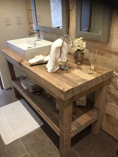 a wooden table with two sinks and towels on it