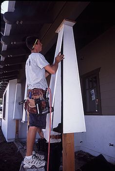 a man painting the side of a building with paint rollers on it's sides