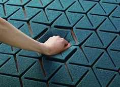 a person with their foot on a blue tile floor that looks like he is holding something in his hand