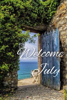 an open door with the words welcome july in front of it and a view of the ocean