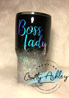 a black tumbler cup with the words boss lady painted on it and glitters