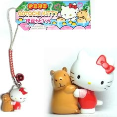 two hello kitty figurines are next to a keychain with a cat on it