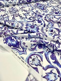 blue and white fabric with floral designs on it's edges, folded to the side