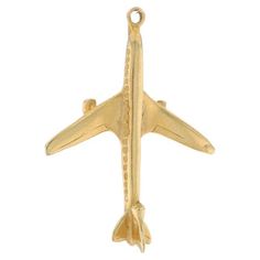 an airplane charm is shown on a white background and it has a gold tone finish