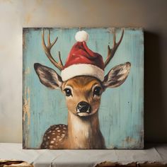 a painting of a deer with a santa hat on it's head is shown