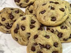 chocolate chip cookies on a white plate with marble counter top in the backround