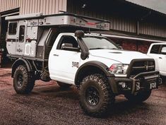 two white trucks parked next to each other in front of a building