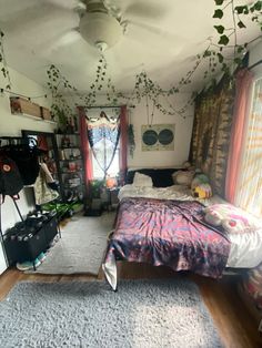 a bedroom with a bed, bookshelf and hanging plants