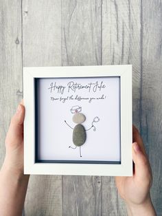 someone is holding up a rock in front of a white frame with the words happy birthday life on it