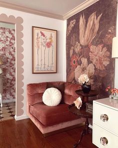 a living room filled with furniture and flowers on the wall