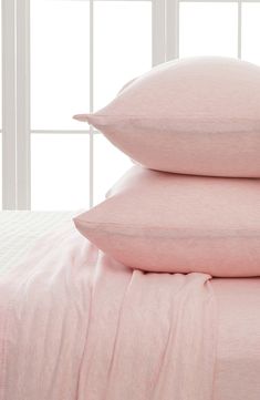 three pink pillows stacked on top of each other