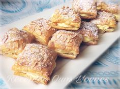 a white plate topped with lots of pastries on top of a blue and white table cloth