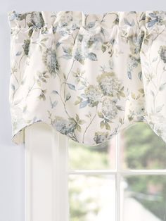 a window with a flowered valance hanging from it's side