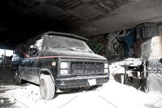 an old van parked under a bridge with graffiti on the walls and ceiling above it