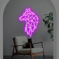 a cat sitting on a chair in front of a wall with a neon giraffe