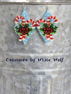 a pair of beaded bow earrings with holly and candy canes on the side