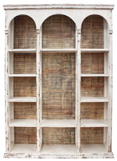 an old white bookcase with many books on the shelves and some writing on it