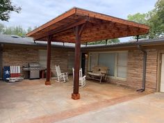 an outdoor covered patio with rocking chairs and bbq