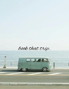 an old vw bus is parked on the side of the road near the ocean