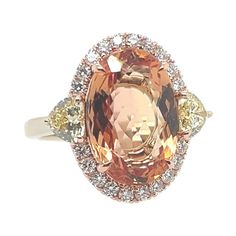 A magnificent 18k Rose and White Gold Natural Imperial Topaz and Diamond Ring. The center stone is a rare peach color natural Imperial Topaz 5.97 carat measuring 13.96x9.44x5.28mm. The center stone is flanked with a matching pair of GIA certified Natural Fancy Yellow heart shapes weighing 0.33 carats (4.3x4.65x2.71mm, VS2 clarity) and 0.31 carats (4.28x4.66x2.65mm, SI1 clarity). Also set are 20 natural round brilliant colorless diamonds weighing 0.30 carats. Total weight of ring is 6 grams, size Luxury Yellow Topaz Ring Elegant, Luxury Yellow Topaz Ring, Vintage Yellow Topaz Engagement Rings Erstwhile Jewelry, Luxury Yellow Topaz Ring With Polished Finish, Luxury Polished Yellow Topaz Ring, Yellow Rings, Imperial Topaz, Yellow Heart, Colorless Diamond