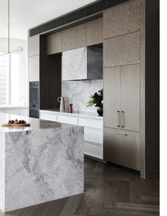 a kitchen with marble counter tops and cabinets