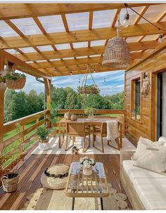 a wooden deck with wicker furniture and plants on the table in front of it