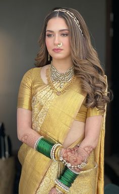 a woman in a yellow sari and green jewelry