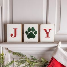 a christmas stocking hanging on a mantle with the word joy written in blocks