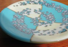 a blue and white plate sitting on top of a wooden table