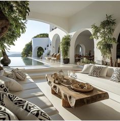 an outdoor living area with couches, tables and potted plants